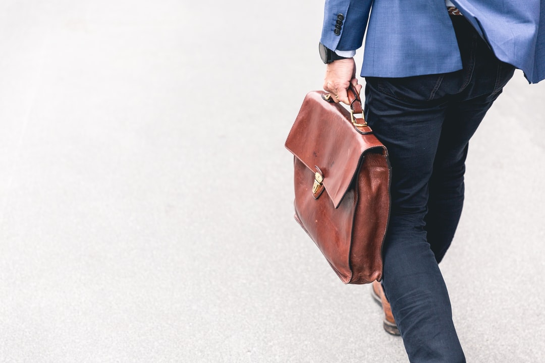 A person carrying a briefcase, heading to search for jobs in business administration.
